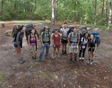 Group picture outside with people wearing backpacks